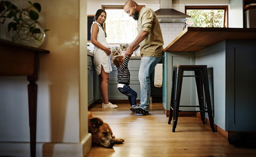 Family and dog roughhousing in kitchen