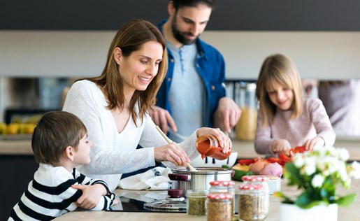Family of four prepping dinner in the kitchen