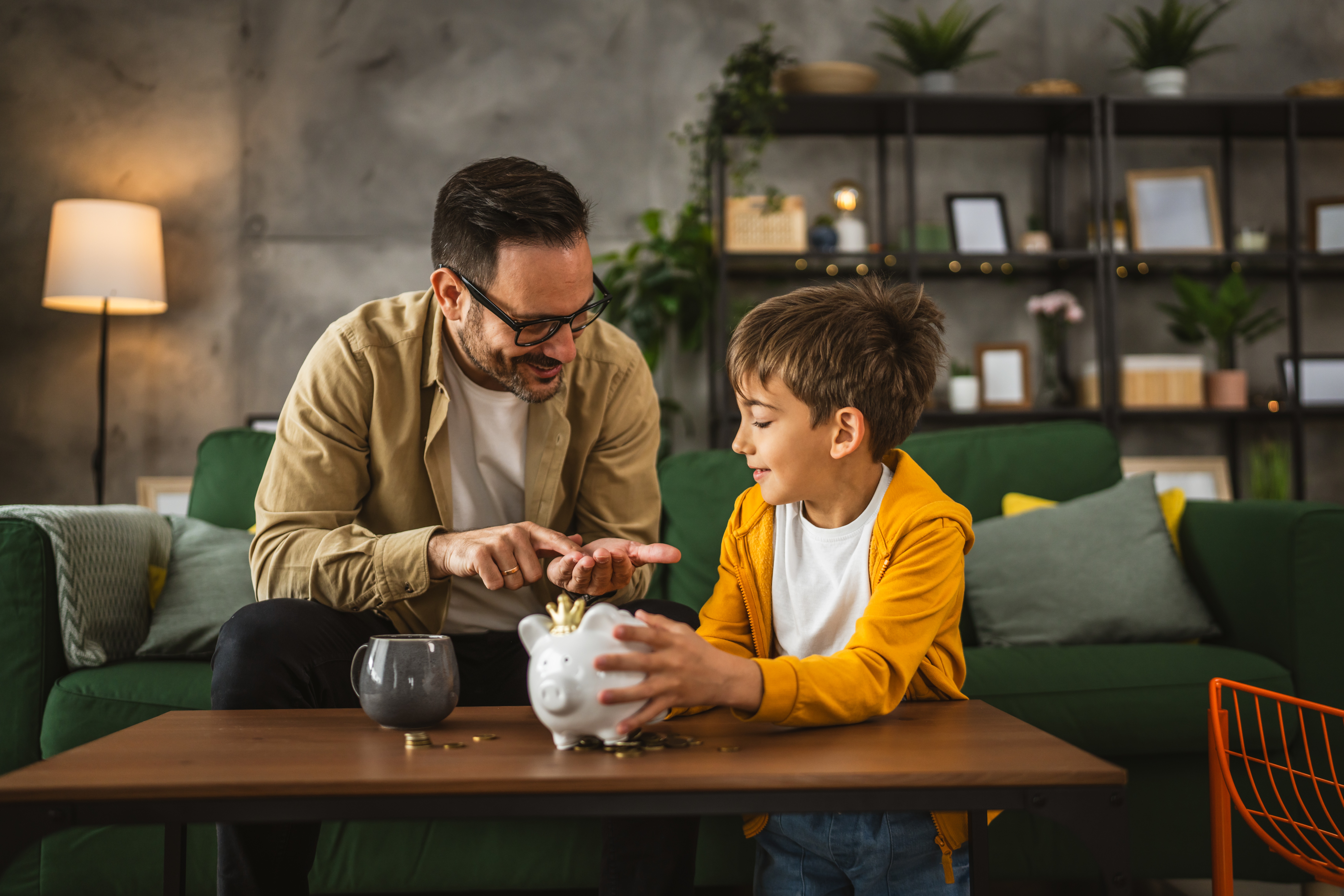 Adult with child learning about a piggy bank