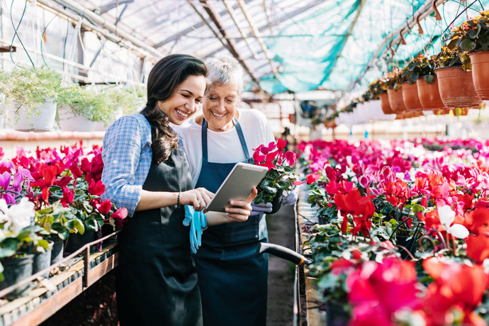 Two females looking at iPad in Greenhouse.