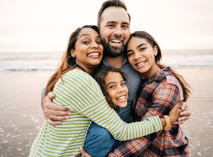 Family hugging each other on the beach