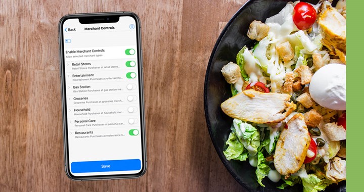 An iPhone with Card Control open sitting next to a chicken salad.