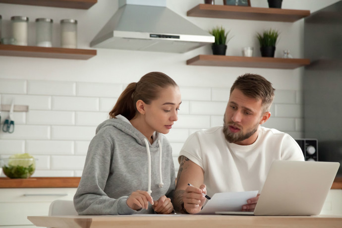 Millennial couple comparing bills