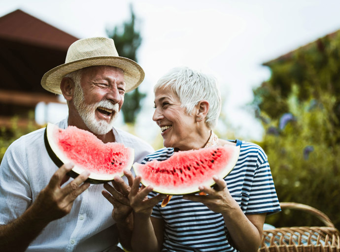 An older couple eating watermelon