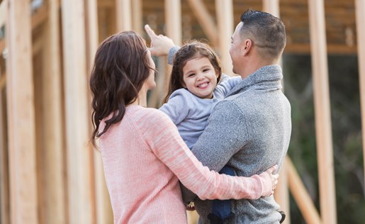 Couple and baby looking at their home being built