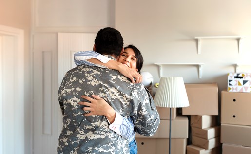 Wife and veteran husband hugging in new home