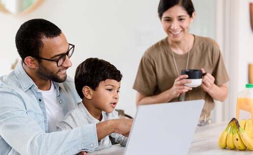 Parents and child working over a laptop