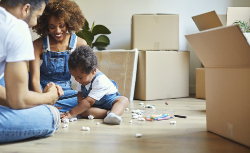 Two parents and their baby playing with packing peanuts from unpacking boxes