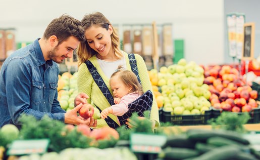 A family of three in the produce section of a grocery