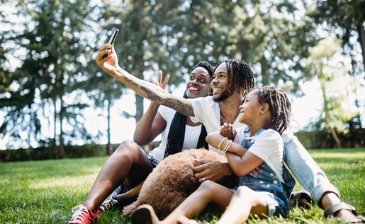 A family of three taking a selfie with their dog