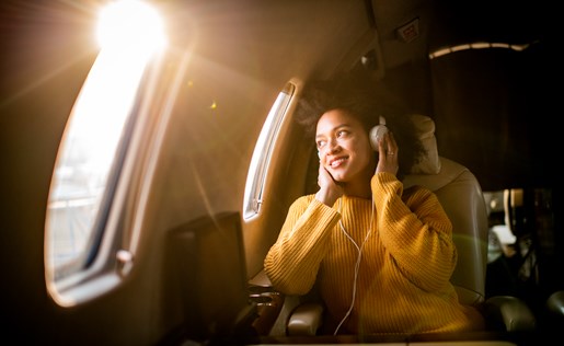 A woman listening to headphones on an airplane
