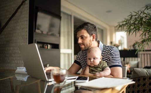 A father and his baby in front of a laptop