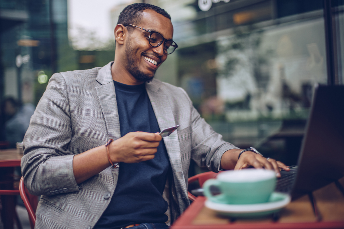 Man making an online purchase at a coffee shop.