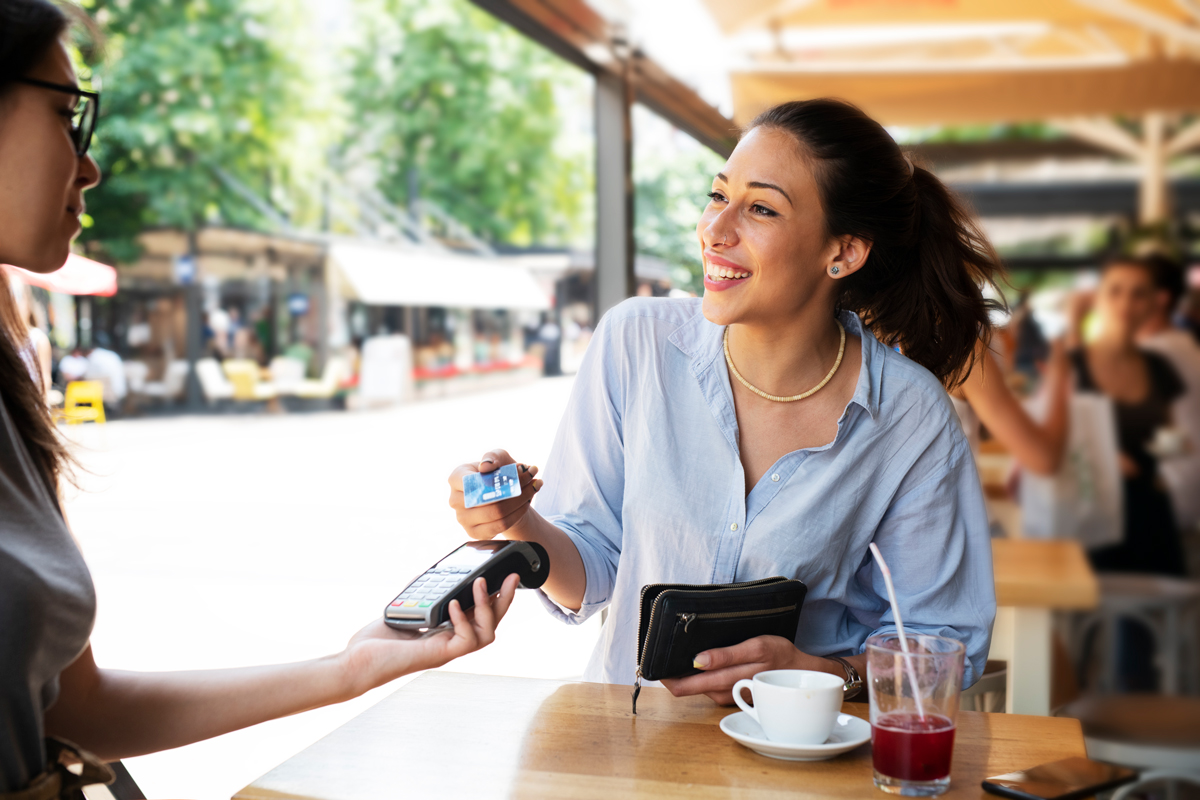 Woman making tap purchase with her credit card.