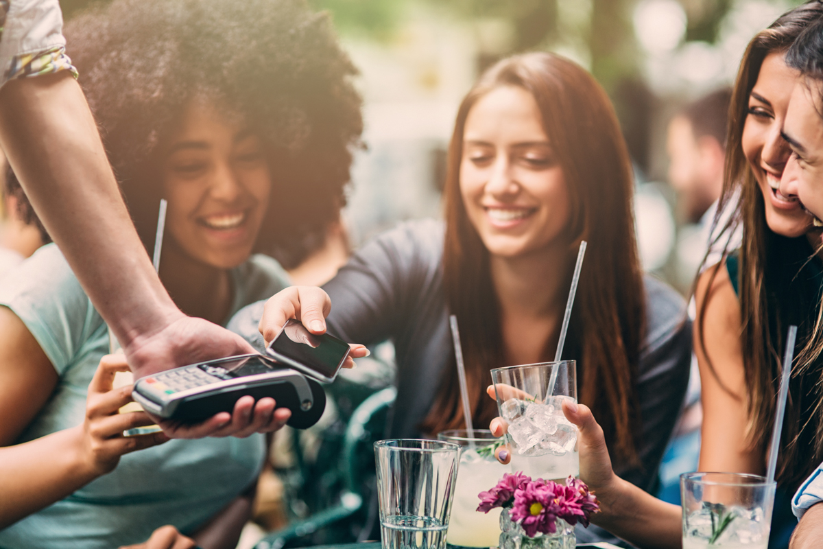 A woman paying for drinks with her phone 