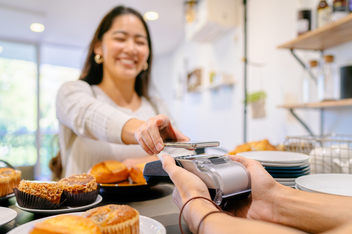 A woman paying for breakfast with her phone