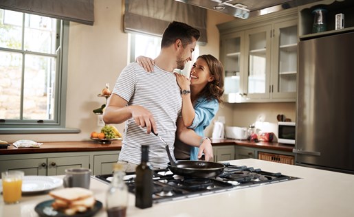 A couple cooking in their kitchen.