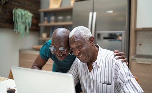 An older couple in front of their laptop.