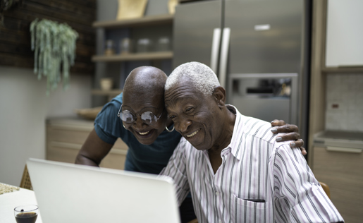 An older couple in front of their laptop.