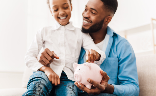 A father and daughter saving money in a piggy bank