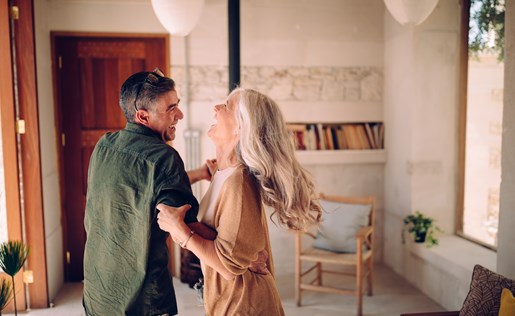An older couple dancing in their home