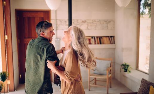 An older couple dancing in their home