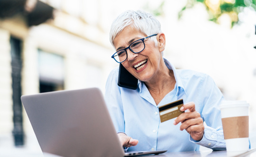 A woman on the phone making an online purchase with her credit card