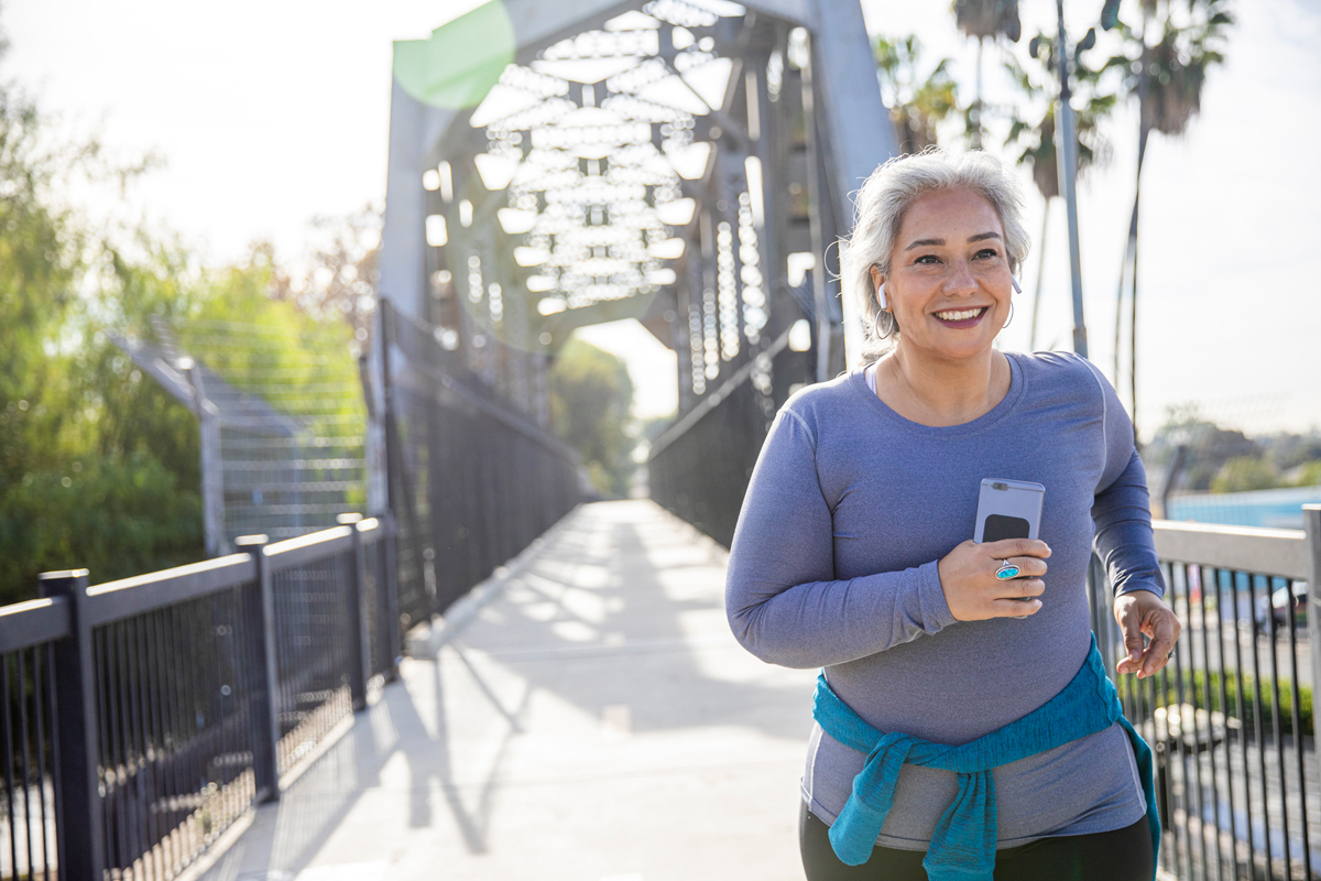 Woman running outside over a bridge.