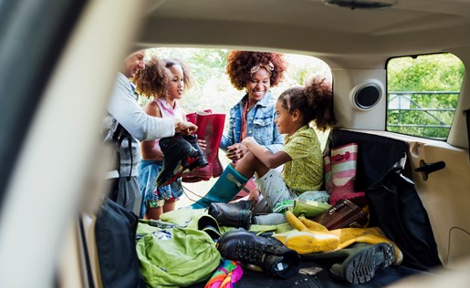 Family of four loading up the car for a trip