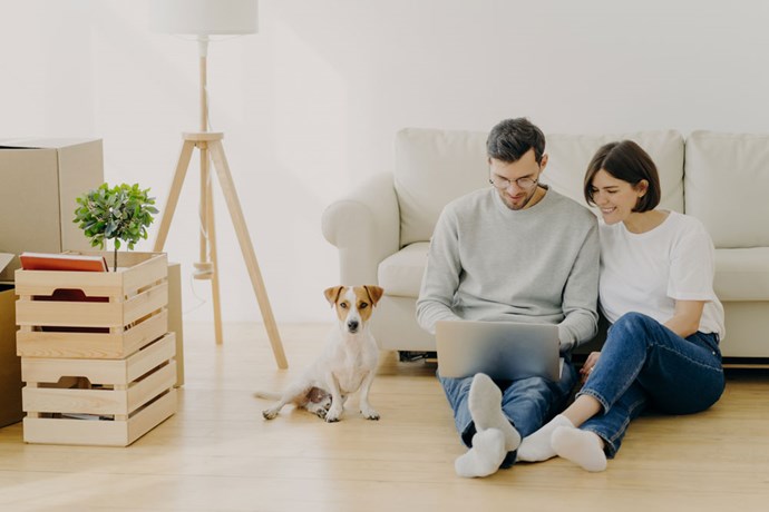 Couple in their new home with their dog.