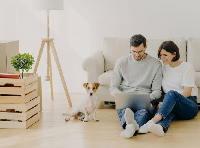 Couple in their new home with their dog.