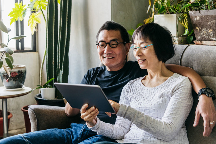 Couple watching a webcast on their tablet.