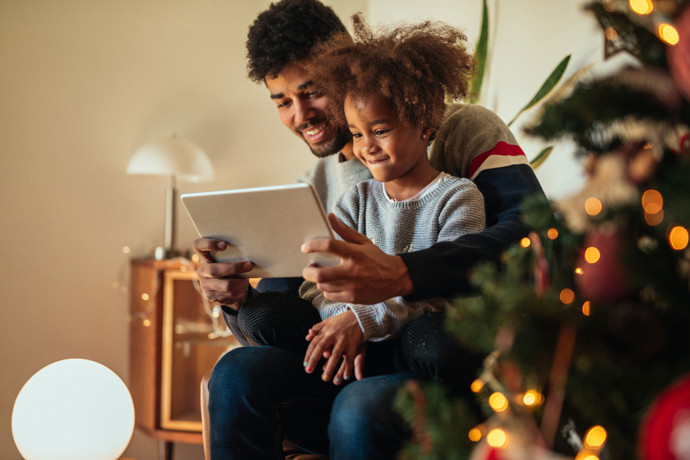 Father and daughter watching webcast on their tablet.