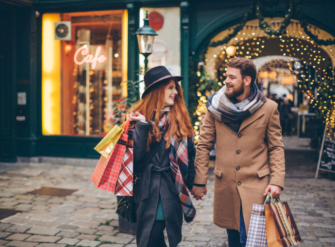 A couple holiday shopping at night.