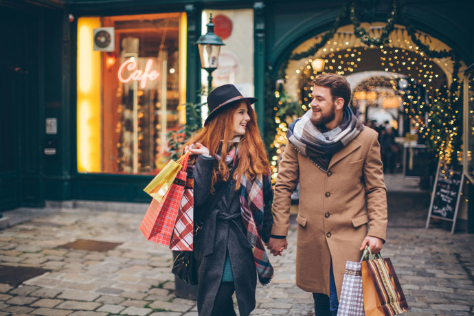 A couple holiday shopping at night.
