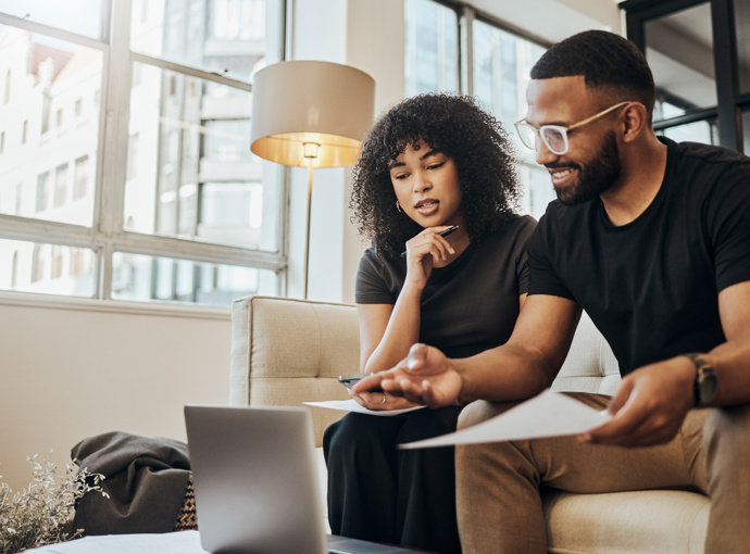 A couple sitting in front of their laptop