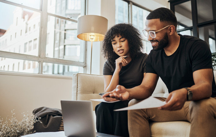 A couple sitting in front of their laptop