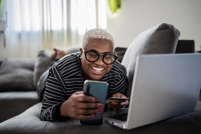 A woman laying on the floor in front of her laptop